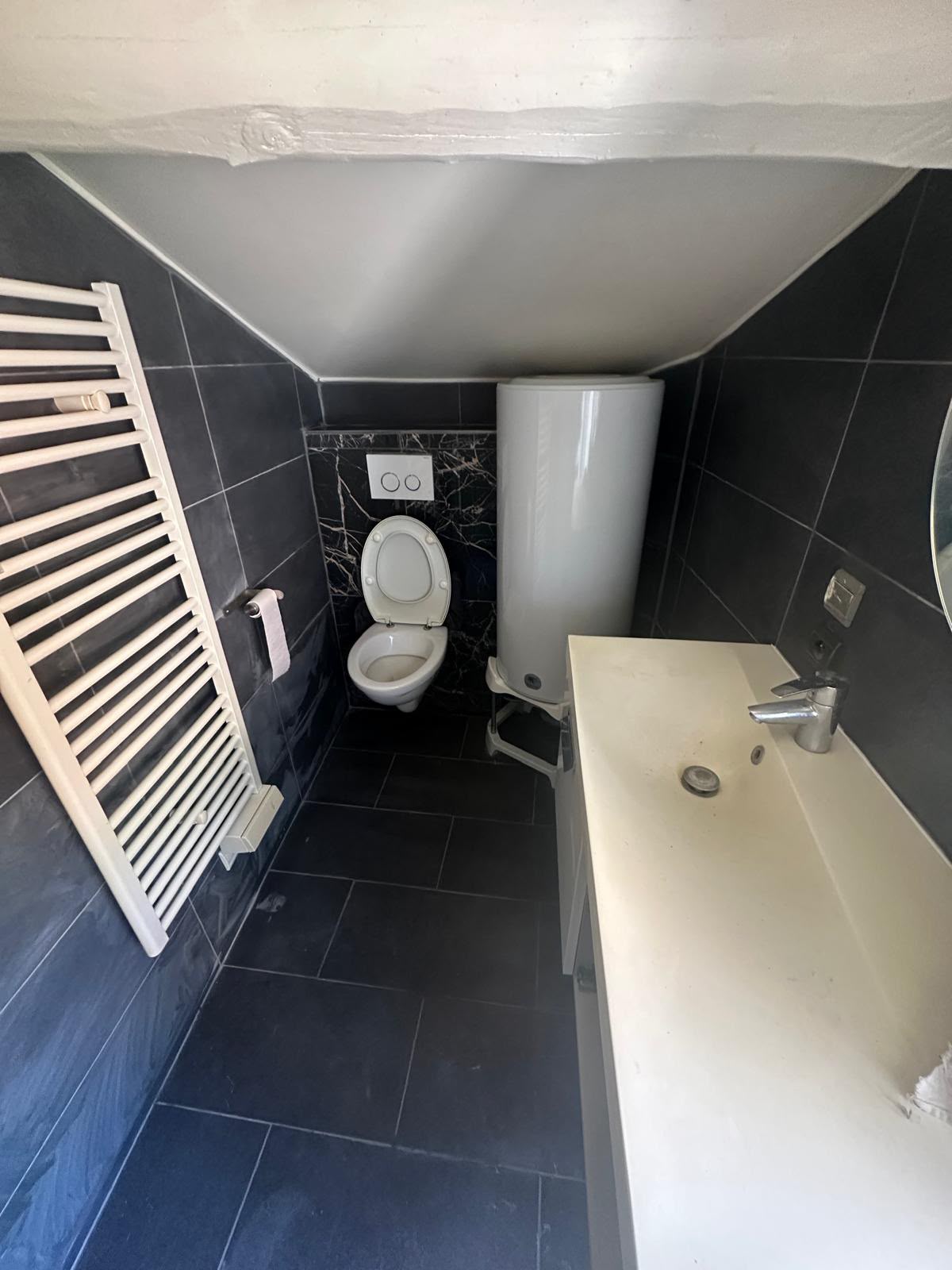 Salle de bain terminée, faïence et carrelage gris foncé, WC suspendu et plan vasque