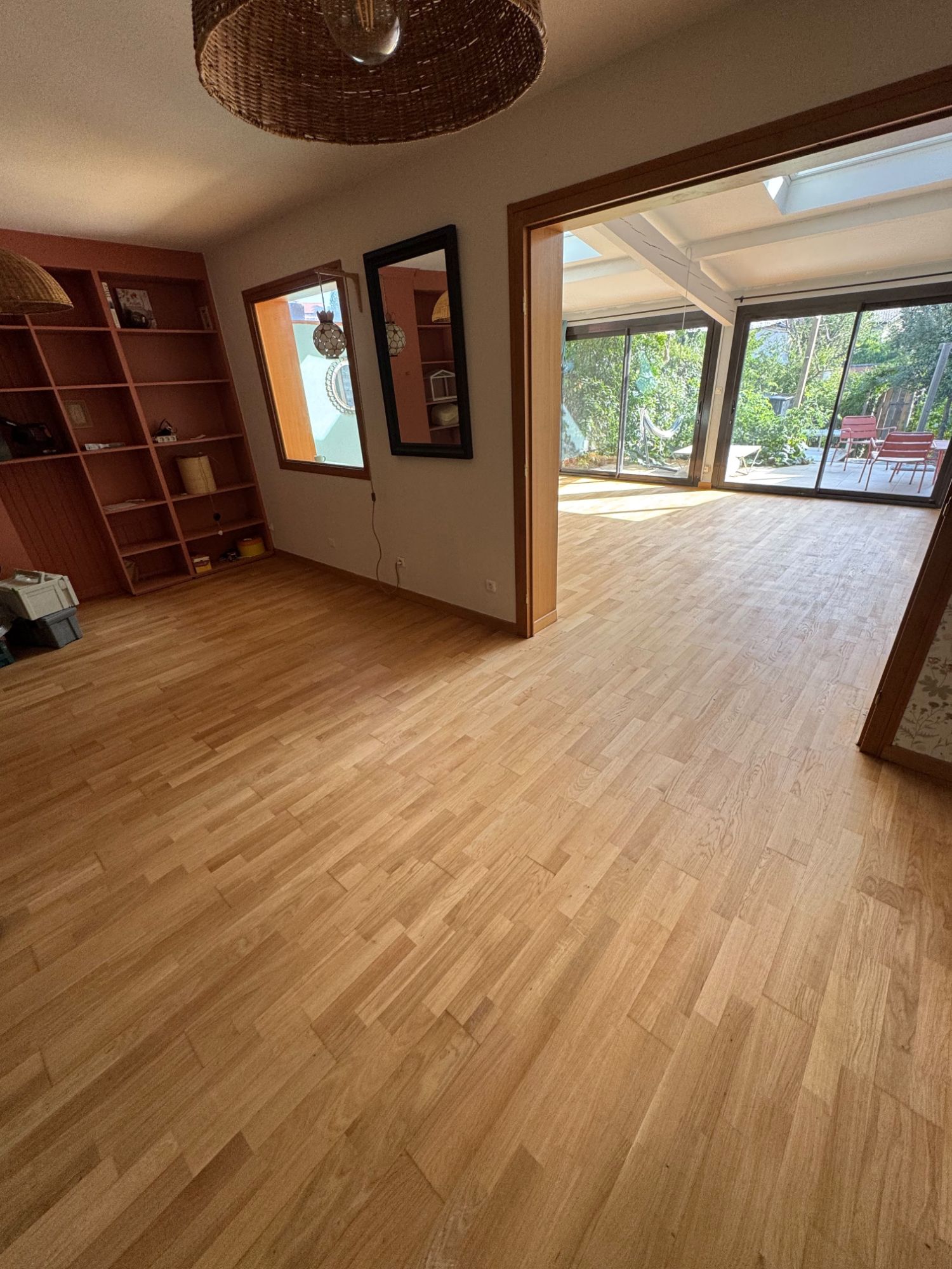 Séjour au parquet en chêne poncé et vitrifié, ouvert sur une véranda