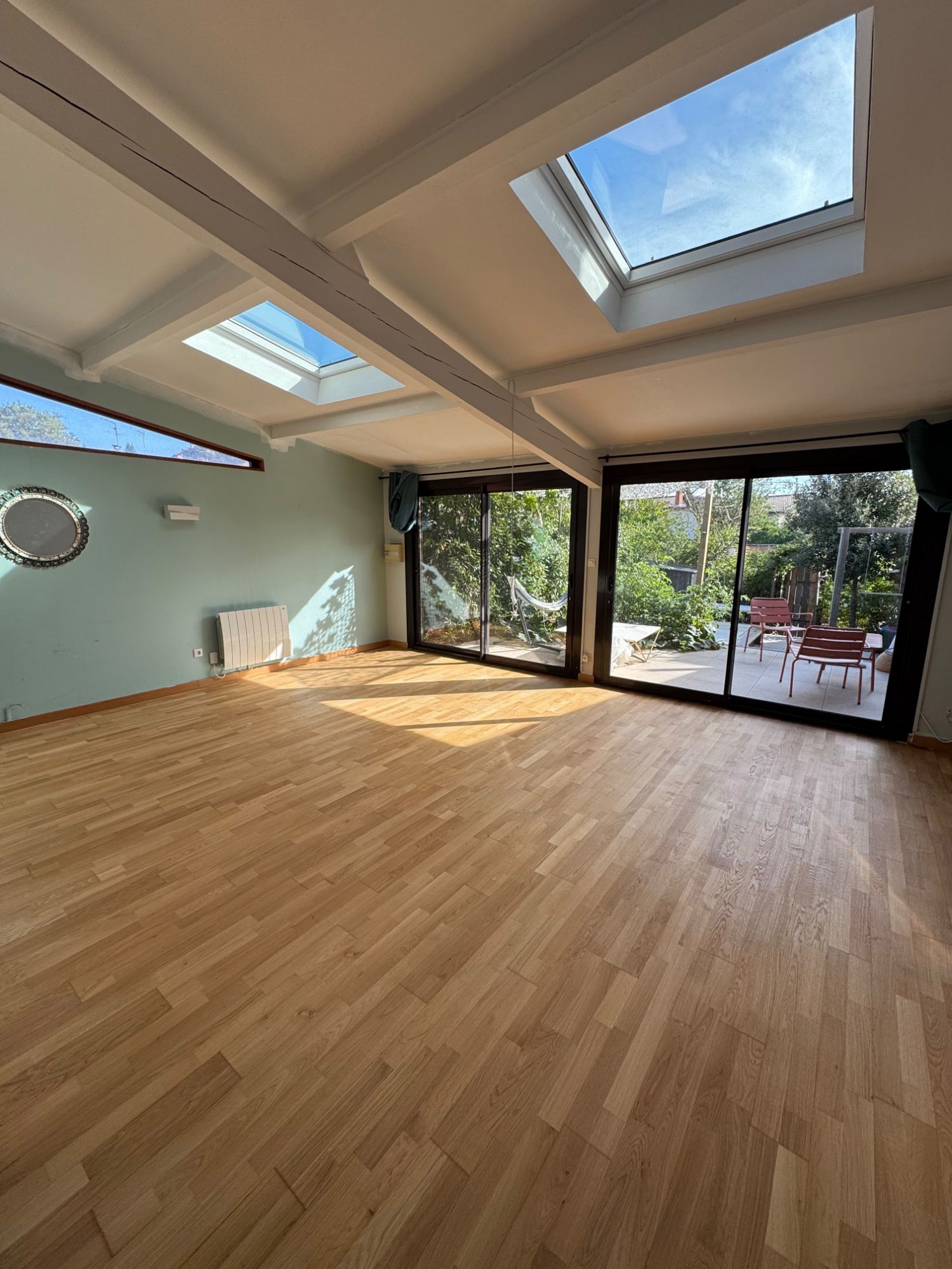 Véranda au parquet vitrifié, lumière des puits de jour sur le bois